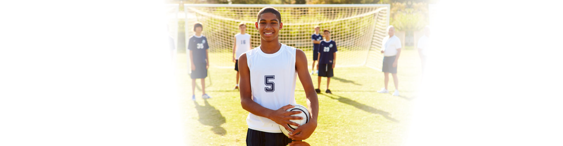 Portrait Of Player In High School Soccer Team Holding Ball Smiling At Camera